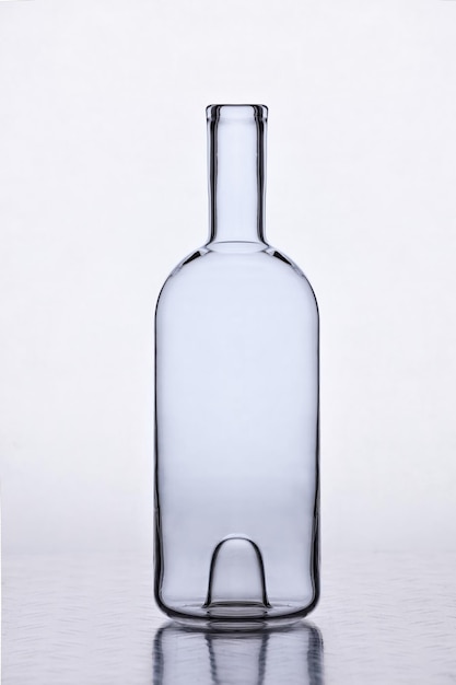 Близкий план бутылки вина на столе на белом фоне