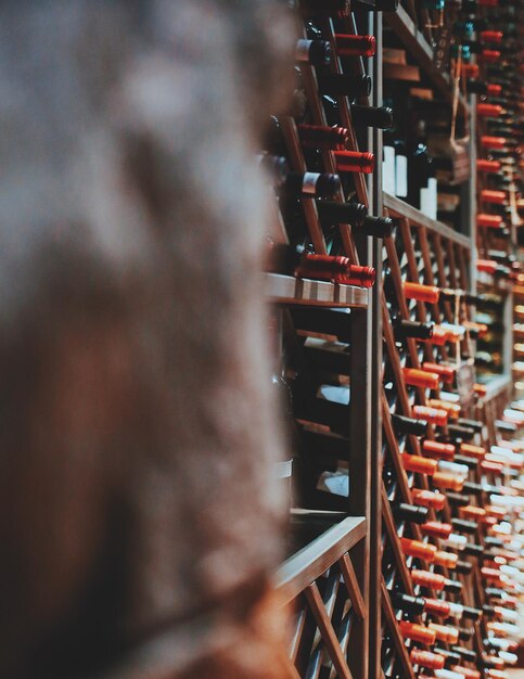 Photo close-up of wine bottles on shelves in store