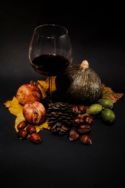 Foto close-up di bicchieri di vino e frutta su sfondo nero