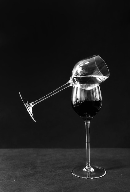 Photo close-up of wineglass on glass against black background