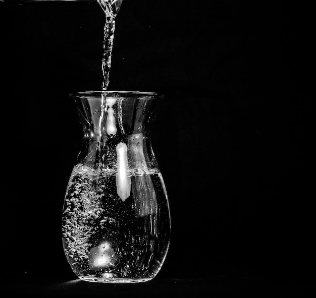 Foto close-up di un bicchiere di vino su tavola su sfondo nero