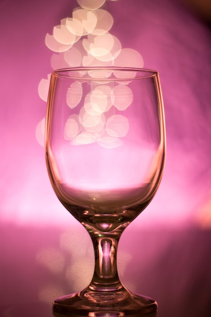 Close-up of wineglass on table against illuminated background