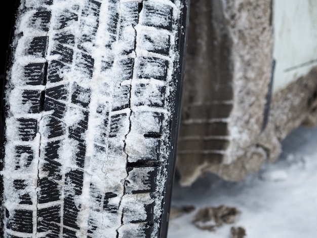 Close-up of a winter car tire tread with snow and ice. the use\
of special tires in the winter season is the basis for safe braking\
and acceleration. high-tech rubber compound.