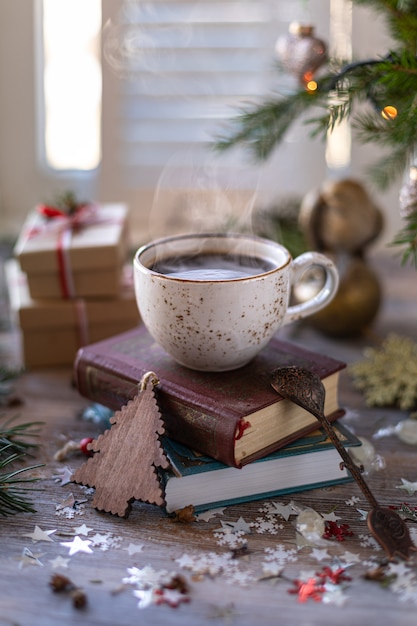 Close-up witte kop van koffie op de feestelijke lijst en giftvakjes op houten achtergrond. Kerstmis of Nieuwjaar