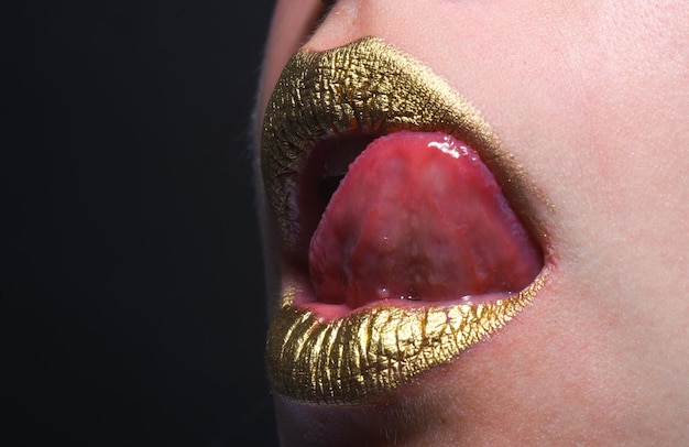 Close-up woma gezicht met gouden lippen gouden verf op mond gouden lippen luxe gouden lippen make-up gouden lip