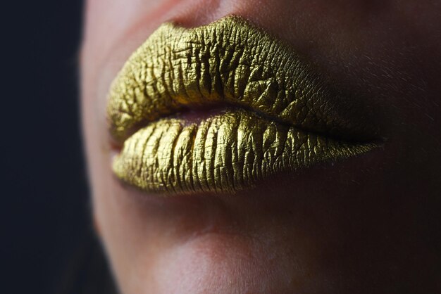 Close-up woma gezicht met gouden lippen gouden verf op mond gouden Lippen luxe gouden lips make-up gouden