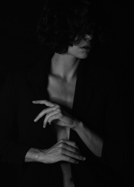 Close-up of woman against black background wearing a black blazer elegant dramatic theatrical