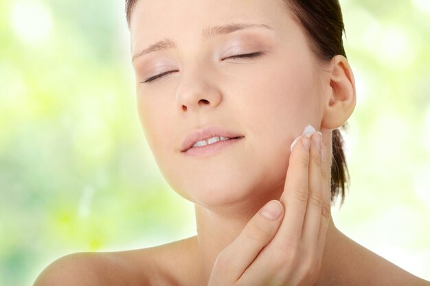 Photo close-up of woman applying moisturizer