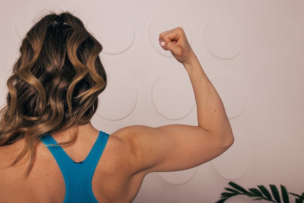 Close up of woman back with flexing her muscles female bodybuilder with perfect biceps