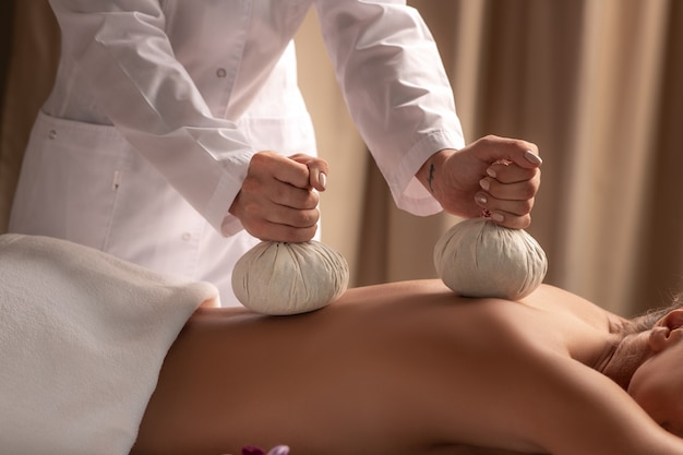 Close up of woman during balls massage in spa salon.