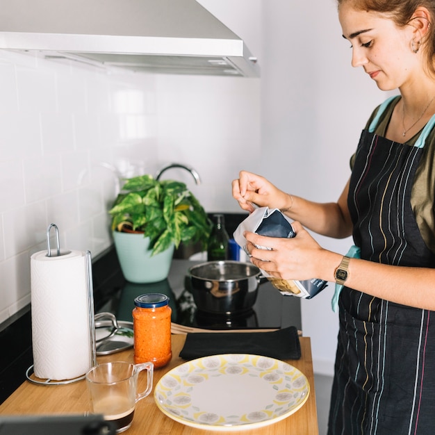 Close-up of woman breaking pasta package