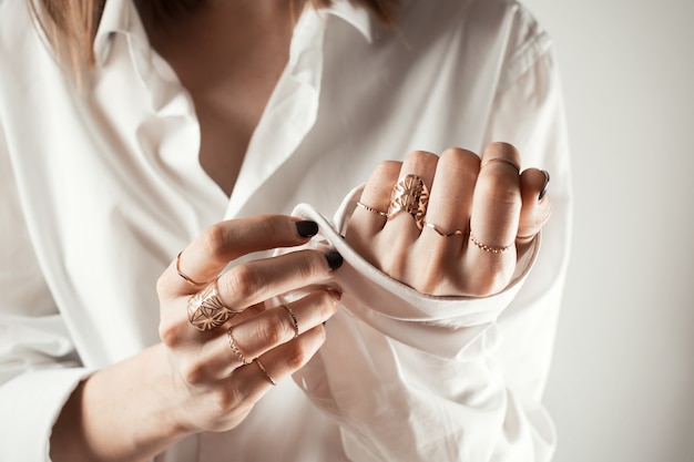 Photo close up of woman buttoning her shirt