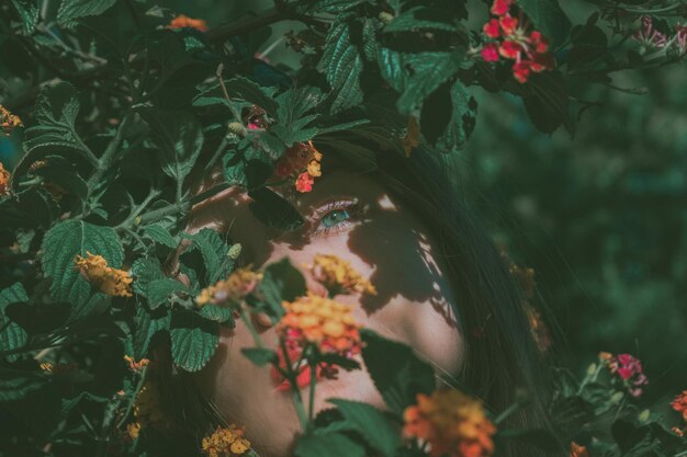 Photo close-up of woman by flowering plants