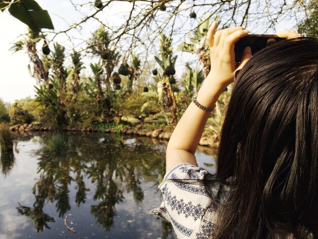 Photo close-up of woman by tree against lake