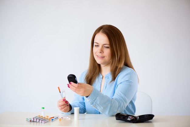  close up of woman checking blood sugar level by glucometer at home