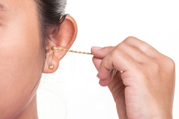 Close up woman cleaning her ear by using cotton bud stick