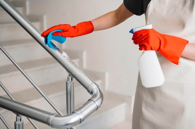 Close-up woman cleaning railing