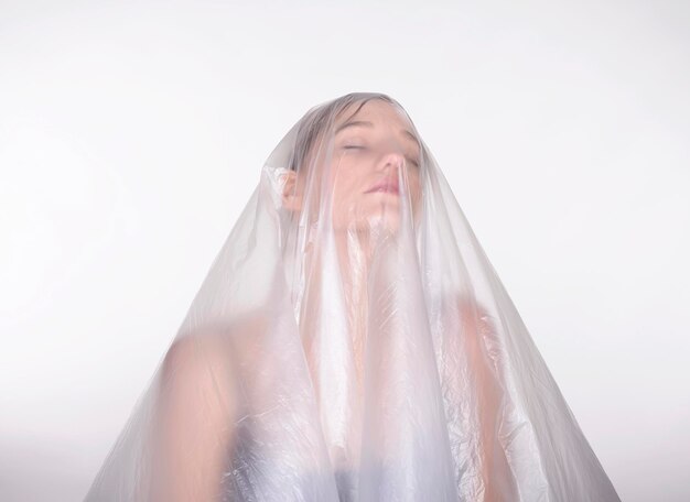 close-up of woman covered in plastic against white background