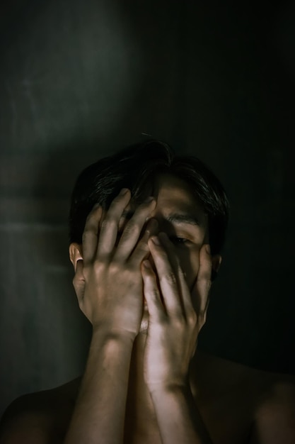 close-up of woman covering face against wall