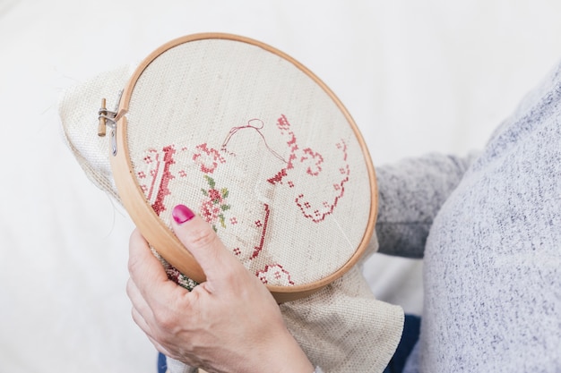 Close-up of a woman cross stitching on hoop