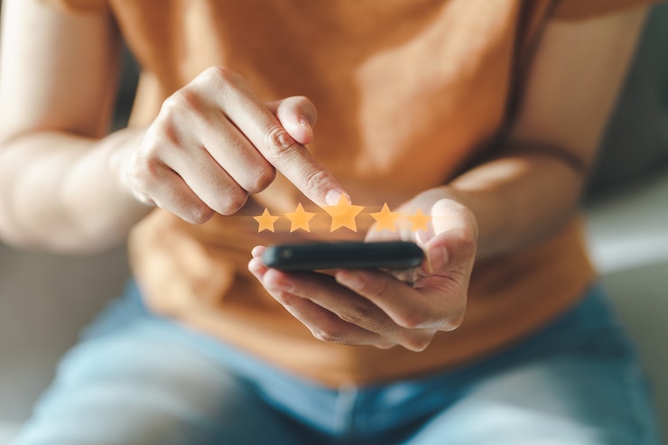 Photo close up of woman customer giving a five star rating on smartphone. review, service rating, satisfaction, customer service experience and satisfaction survey concept.