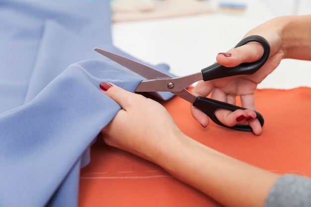 Close up of a woman cutting a blue piece of tissue