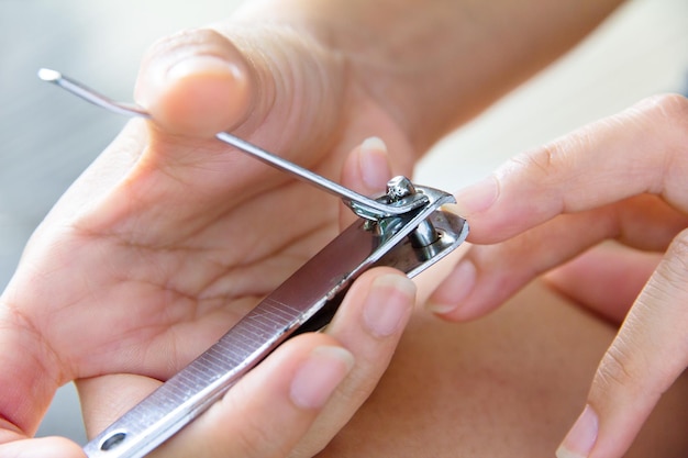 Foto close-up di una donna che taglia le unghie con un taglia-unghie