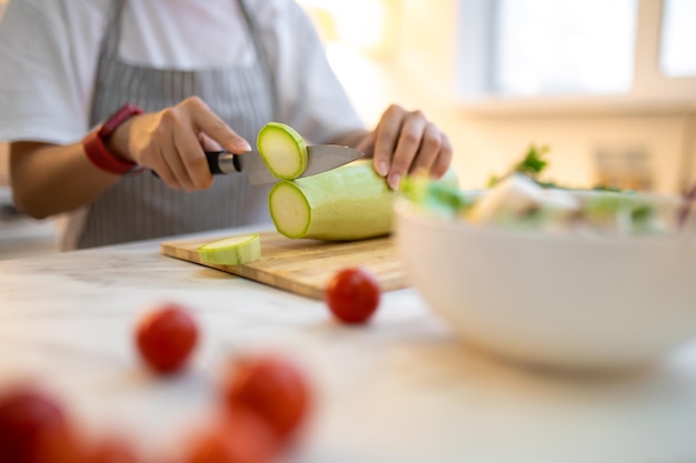 Close up of a woman cutting vegetables on the cutting board