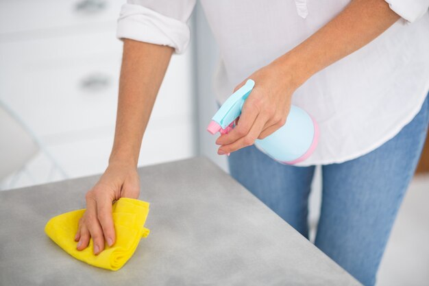 Close up of a woman disinfecting the surfaces