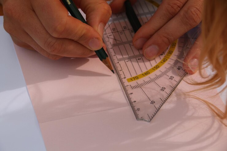 Photo close-up of woman drawing using ruler on paper