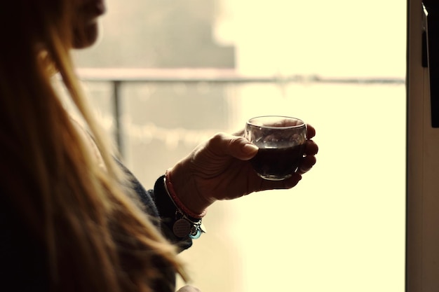 Foto close-up di una donna che beve un bicchiere