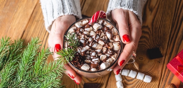 close up woman drinking hot chocolate with marshmallows