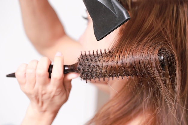 Foto close-up di una donna che asciuga i capelli