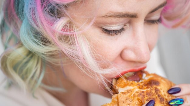 Foto close-up di una donna che mangia un hamburger