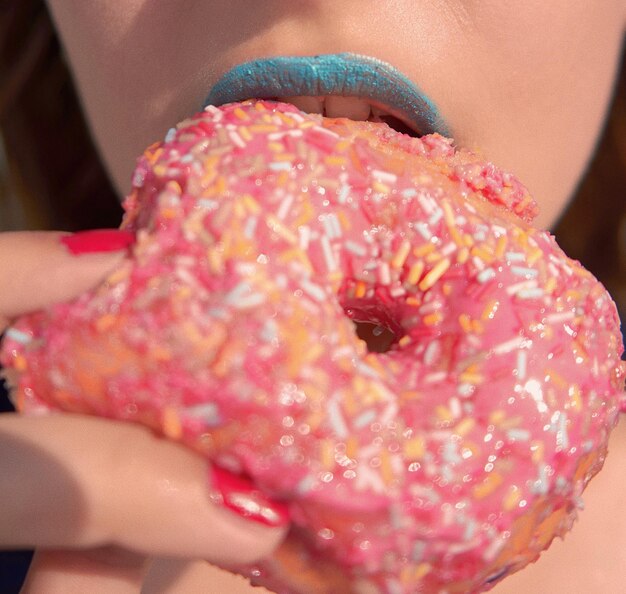 Photo close-up of woman eating donut