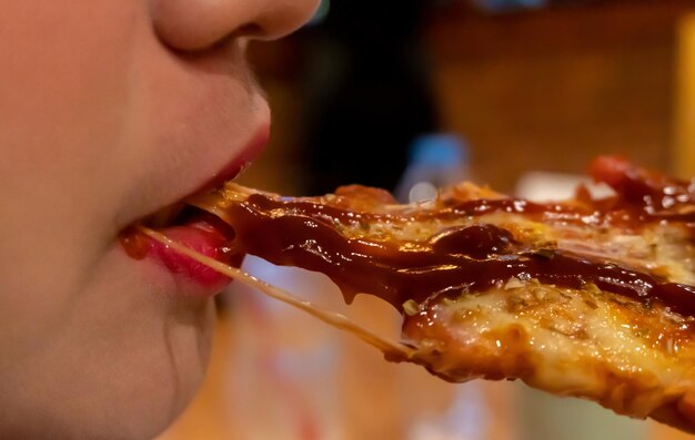 Foto close-up di una donna che mangia la pizza
