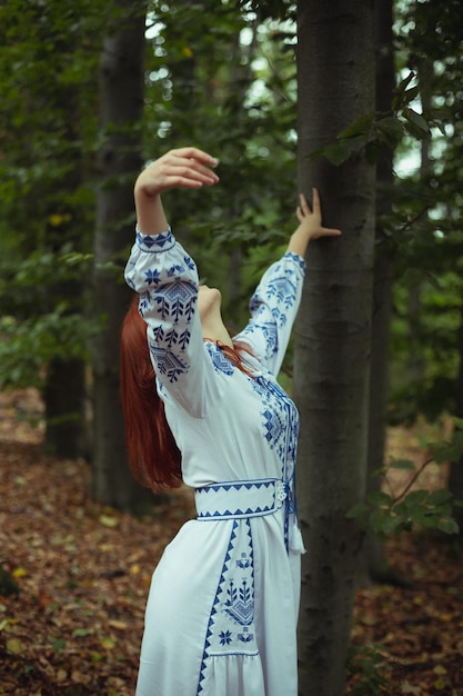 Close up woman in embroidery dress raising arms up concept photo