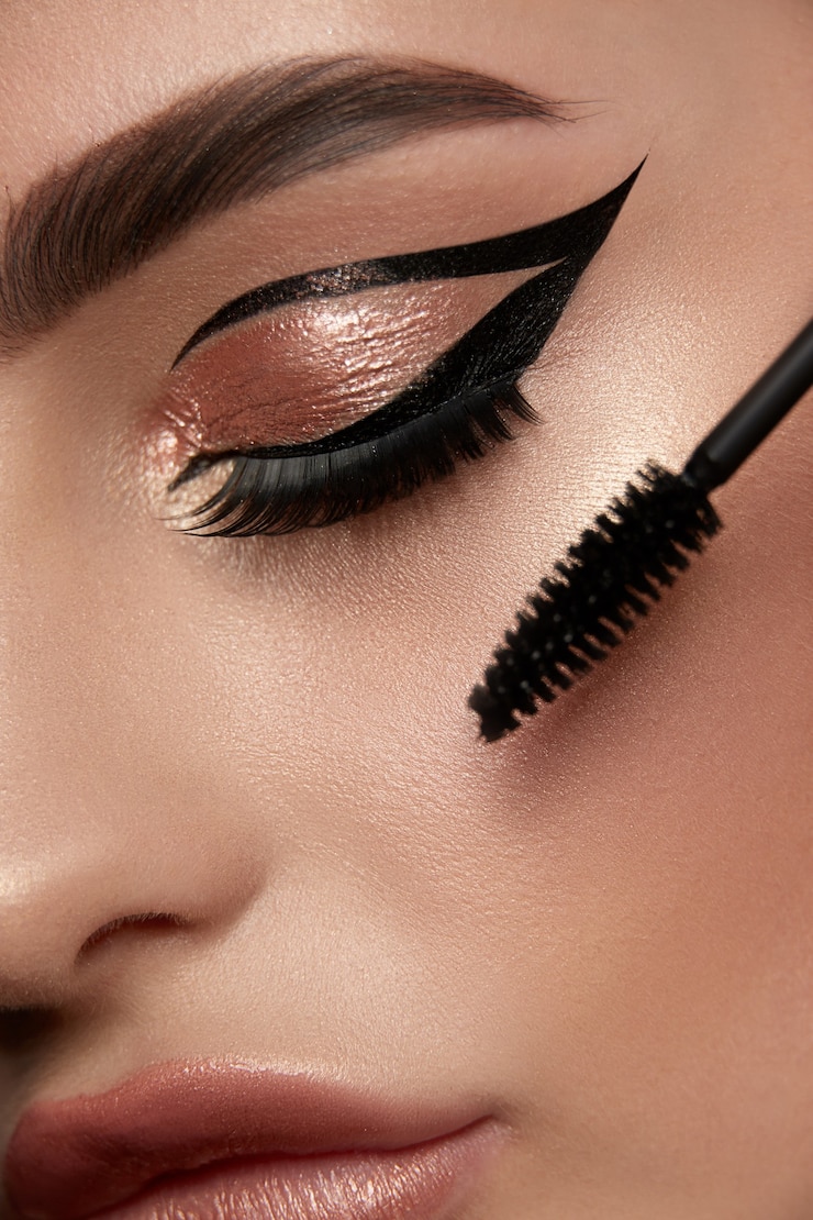 Photo close-up of woman eye with luxury golden make-up and mascara bru