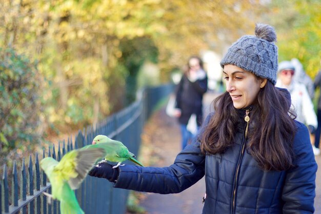 Close-up of woman feeding parrot