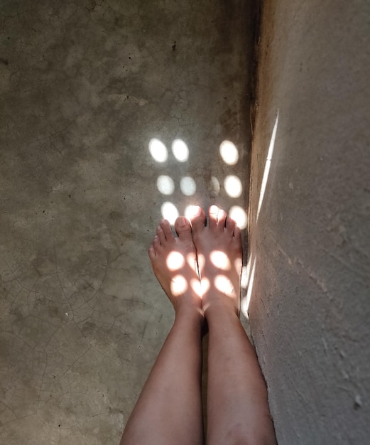 Foto close-up dei piedi di una donna che tiene una luce illuminata