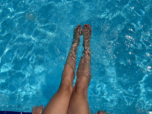 Close up woman feet in swimming poolsummer holiday concept