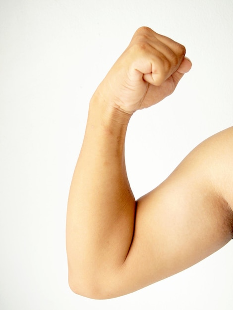 Photo close-up of woman flexing muscles over white background