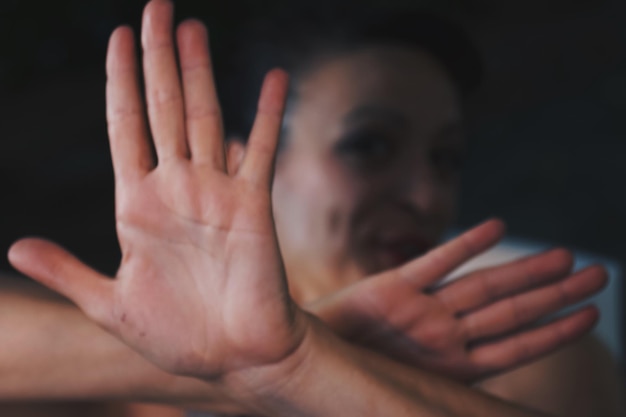 Photo close-up of woman gesturing stop sign in darkroom