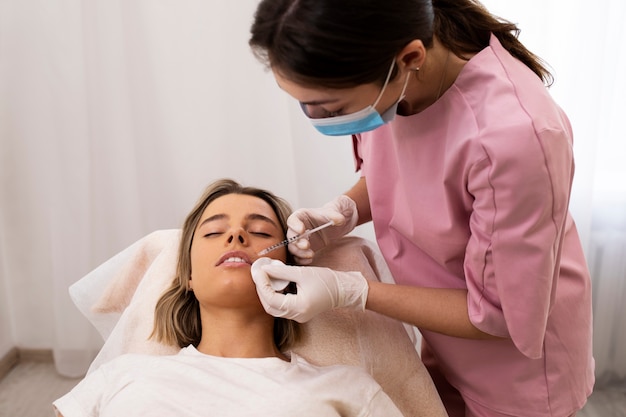 Close up woman getting lip filler at salon