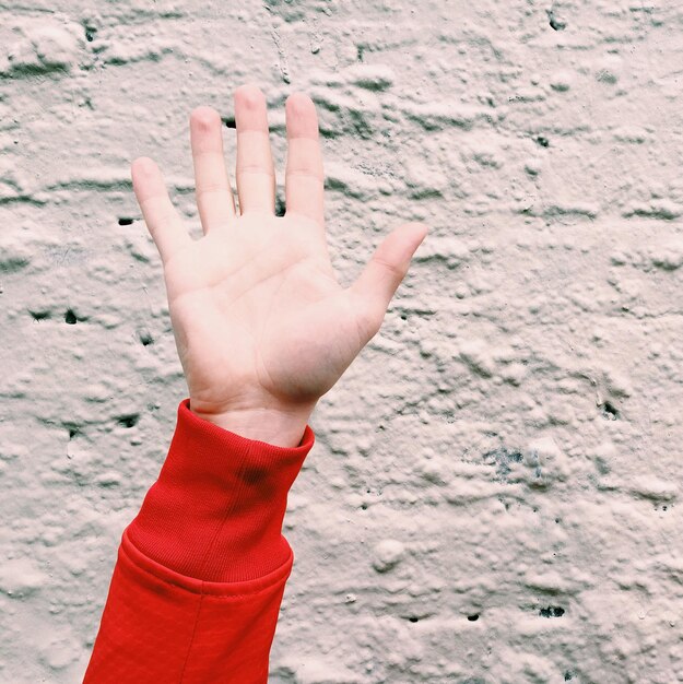 Photo close-up of woman hand against wall