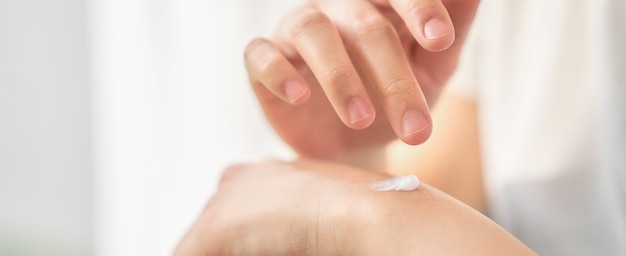 close up of woman hand holding and applying moisturiser.