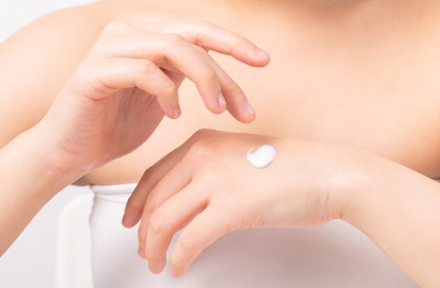 Close up of woman hand holding and applying moisturiser,