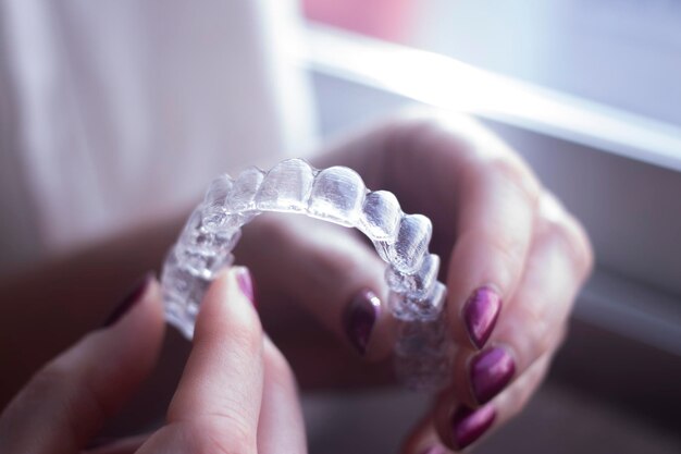 Photo close-up of woman hand holding artificial teeth