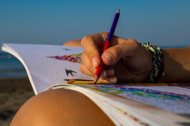 Foto close-up di una donna con la mano che tiene un libro