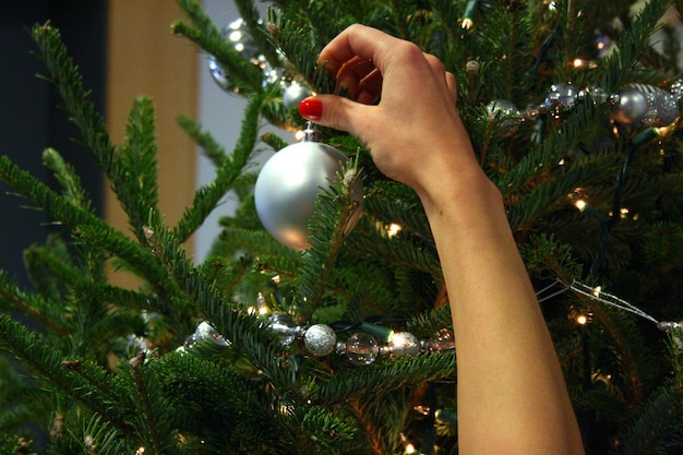 Close-up of woman hand holding christmas tree at home